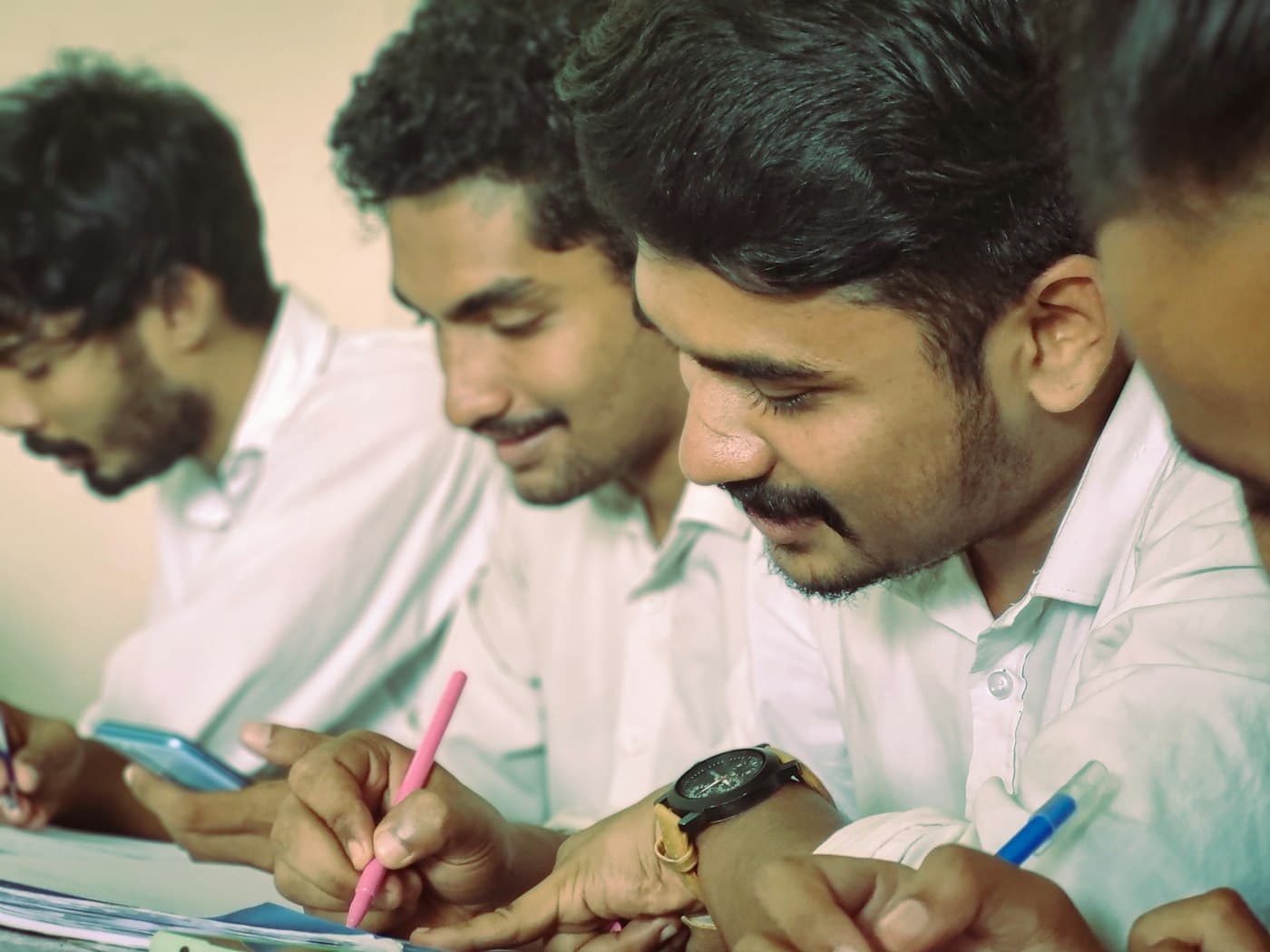 Students practising questions together at a desk