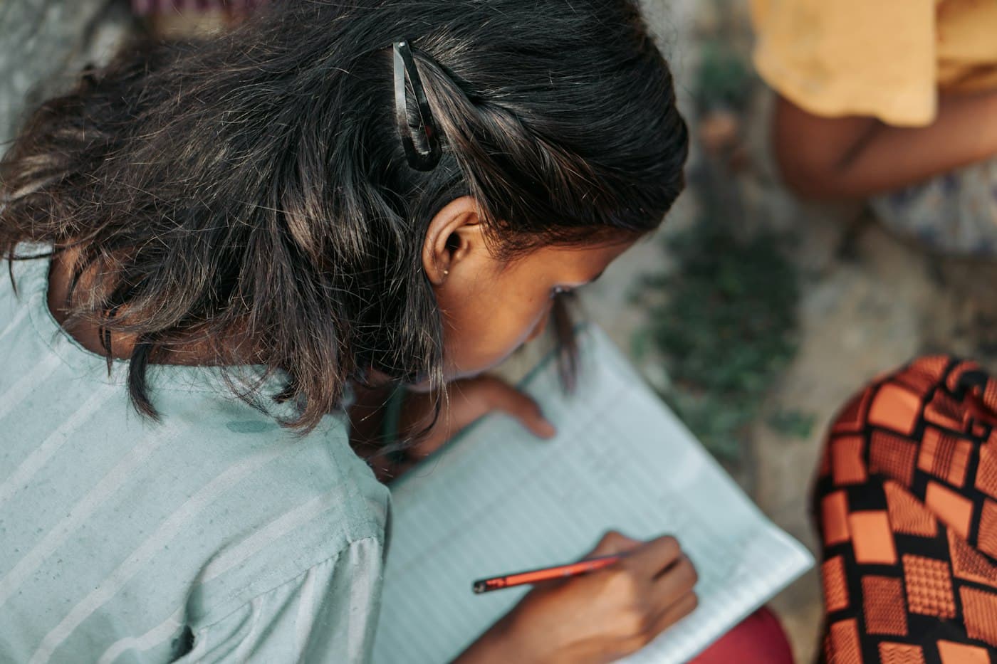 A student writing notes during a study session at home